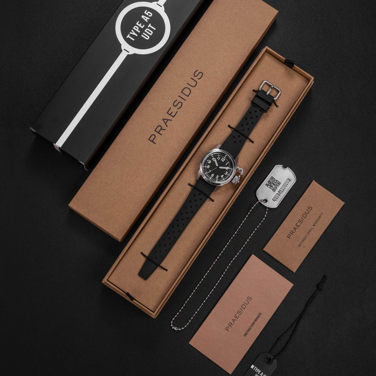 Praesidus A-5 UDT black military field watch with black rubber Tropic strap displayed with packaging box and accessories
