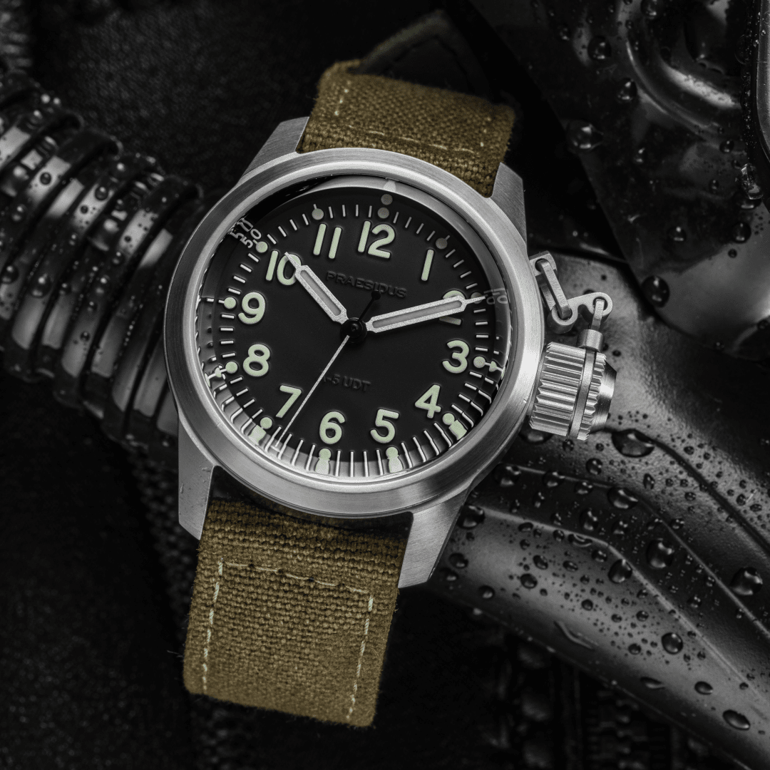 A-5 UDT black military field watch with stock green canvas strap in rugged setting with water droplets