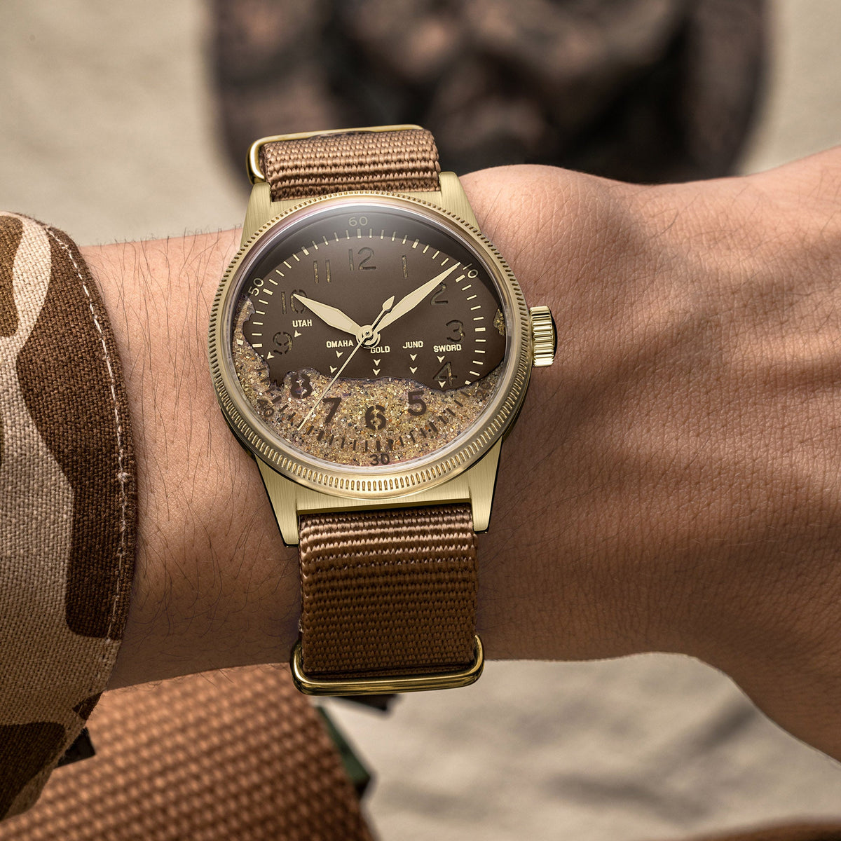 Bronze WWII field watch worn on wrist with military jacket D-Day tribute watch with sand dial
